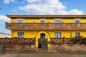 a yellow house with a balcony on top of it at Casa Colonia 1 in SantʼAnna Arresi
