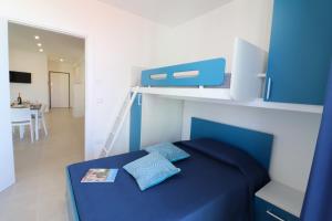 a blue bed with two pillows on it in a room at Holiday home Galatea a Otranto in Otranto