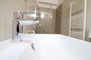 a white sink with a faucet in a bathroom at Holiday home Galatea a Otranto in Otranto +32 photos