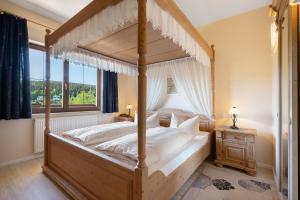a bedroom with a canopy bed and a window at Pension Bergblick in Marienberg