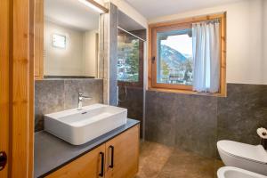 a bathroom with a white sink and a window at Quattropassi Bormio Mortirolo in Bormio +34 photos