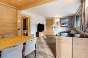 a kitchen and living room with a wooden table and chairs at Quattropassi Bormio Mortirolo in Bormio