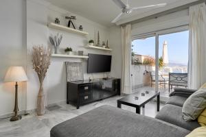 a living room with a couch and a tv at Las Lomas de Marina del Este in Almuñécar