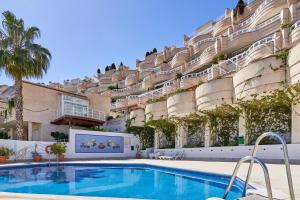 a hotel with a swimming pool in front of a building at Las Lomas de Marina del Este in Almuñécar