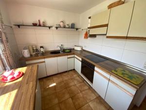 a kitchen with white cabinets and a wooden counter top at Haus Sonnengarten in Seelbach +12 photos