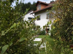 a white chair in the yard of a house at Haus Sonnengarten in Seelbach