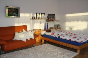 a bedroom with a bed and a chair at Haus Sonnengarten in Seelbach