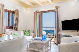 a living room with a large window and a tv at Caldera Studios in Astypalaia