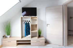 a room with a staircase with a tv and a closet at Ferienwohnung Am Palmengarten in Marktbergel