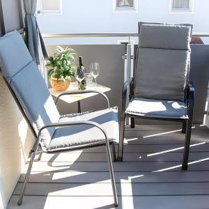 a pair of chairs and a table on a balcony at Ferienwohnung Am Palmengarten in Marktbergel