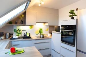 a kitchen with white cabinets and a white refrigerator at Ferienwohnung Am Palmengarten in Marktbergel