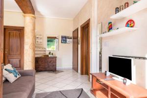 a living room with a couch and a tv at Appartamento vista lago in Sulzano
