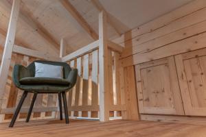 a green chair in a room with wooden walls at Peintnerhof Percha in Perca
