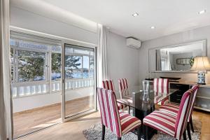 a dining room with a glass table and red chairs at Casa Vista Rio in Ferragudo