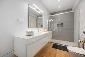 a white bathroom with a sink and a shower at Casa Vista Rio in Ferragudo +20 photos
