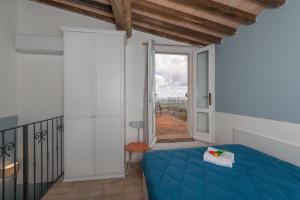 a bedroom with a blue bed and a large window at Lecasedicatia in Villamagna