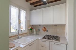 a kitchen with white cabinets and a sink and a stove at Lecasedicatia in Villamagna