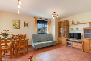 a living room with a dining table and a television at Sueños de Guara Casa rural in Casbas de Huesca