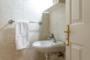 a bathroom with a white sink and a white towel at En Tino 4 in Tinos