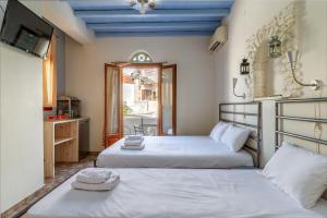 a bedroom with two beds and a tv on the wall at En Tino 4 in Tinos