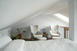 a bedroom with two chairs and a bed at Flutgold Dangast in Dangast