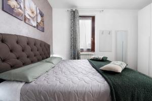 a bedroom with a bed with a tufted head board at Vigilio house in Calco