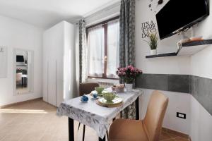 a dining room with a table with chairs and a television at Vigilio house in Calco