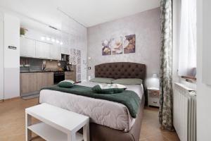 a bedroom with a large bed with a green blanket at Vigilio house in Calco