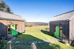 zwei Scheunen mit grünen Türen in einem Hof in der Unterkunft Tiny Houses der Dorfscheune in Bieselberg