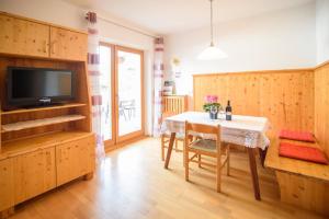 a dining room with a table and a television at Peter Paul Terrasseapp Burgenblick in Appiano sulla Strada del Vino
