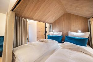 a bedroom with two beds with blue pillows at Avia Living Elisabeth in Brunico