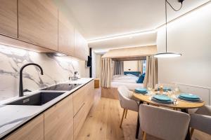 a kitchen and dining room with a table and a bed at Avia Living Elisabeth in Brunico