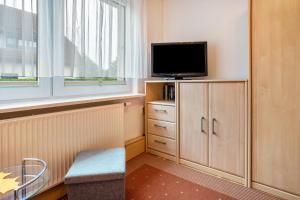 a small room with a tv and a window at Prerow Am Deich - Ferienwohnung 2 in Prerow