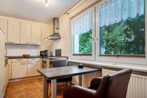a kitchen with a table and chairs and a window at Prerow Am Deich - Ferienwohnung 2 in Prerow