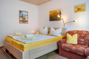 a bedroom with a bed and a couch and a chair at Prerow Am Deich - Ferienwohnung 2 in Prerow