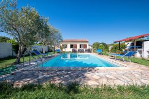 a swimming pool in a yard with a house at Gadem House in Alghero
