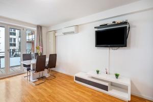 a living room with a flat screen tv on a wall at Aldars Urban Suite No.10 in Munich