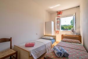 a small room with two beds and a window at Gadem House in Alghero