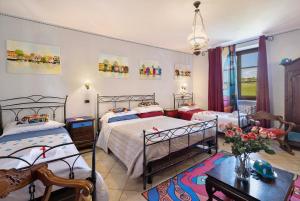 a bedroom with two beds and a table at Locanda Casa Bardacchino in Mango