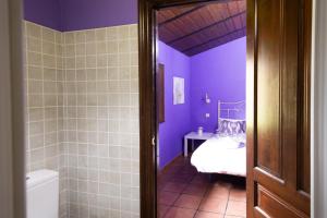 ein lila Badezimmer mit Bett und Dusche in der Unterkunft Amama in Karrantza