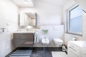 a white bathroom with a sink and a toilet at Ferienwohnung Schatz in Albstadt +24 photos