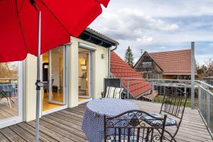 a patio with a table and an umbrella on a deck at Ferienwohnung Schatz in Albstadt