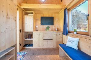 ein winziges Haus mit einer blauen Couch in einem Zimmer in der Unterkunft Tiny Houses der Dorfscheune in Bieselberg