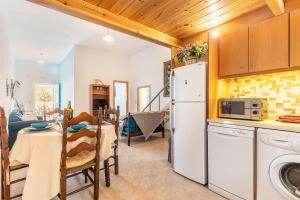 a kitchen and dining room with a table and a refrigerator at Beach Pearl in Lachania