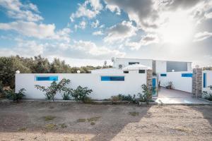 a white house with blue windows at Beach Pearl in Lachania