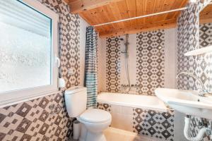 a bathroom with a toilet and a sink and a tub at Beach Pearl in Lachania +18 photos