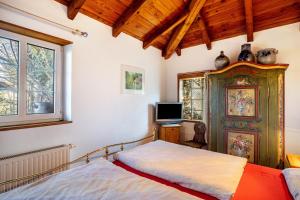 a bedroom with a bed and a tv in it at Maison Fleurie in Mitschdorf