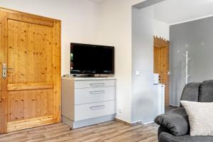 a living room with a flat screen tv on a dresser at Ferienhaus Dorfidyll in Bugewitz