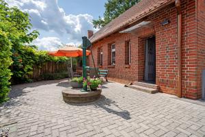 a brick building with a patio with an umbrella at Ferienhaus Dorfidyll in Bugewitz