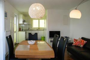 a dining room with a wooden table and chairs at Obst- und Ferienhof Schäfler in Hattnau